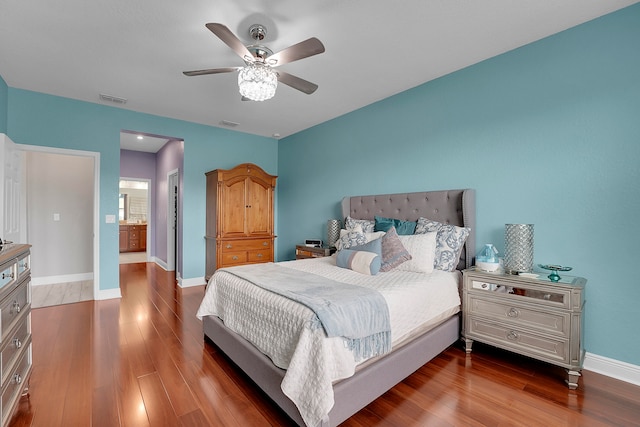 bedroom with ceiling fan, ensuite bathroom, and hardwood / wood-style flooring