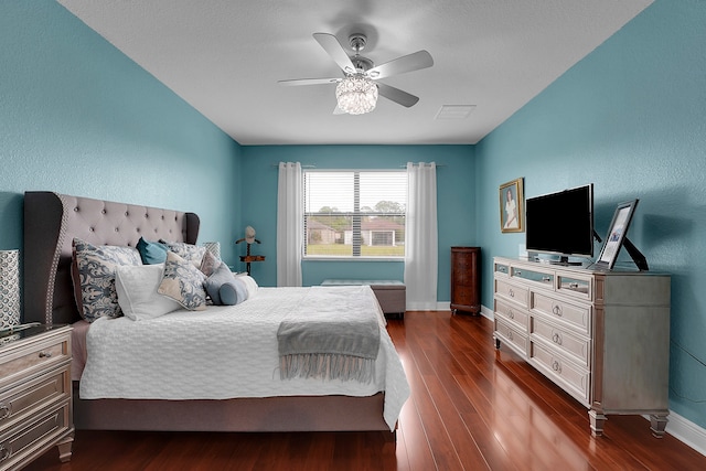 bedroom with ceiling fan and dark wood-type flooring