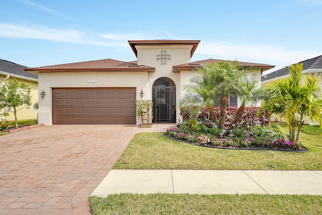 mediterranean / spanish house featuring a front yard and a garage