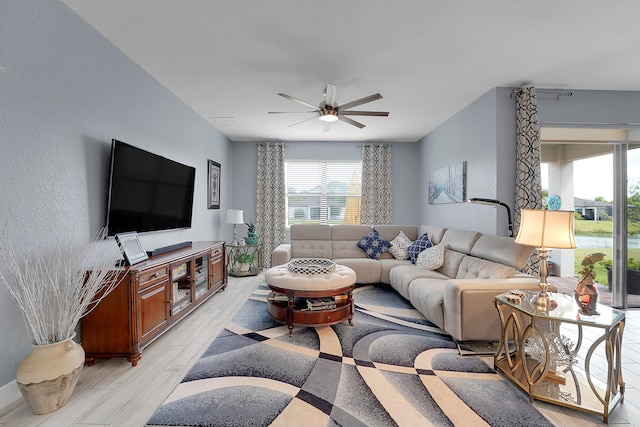 living room with ceiling fan and light wood-type flooring