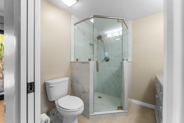 bathroom with a shower with door, vanity, and toilet