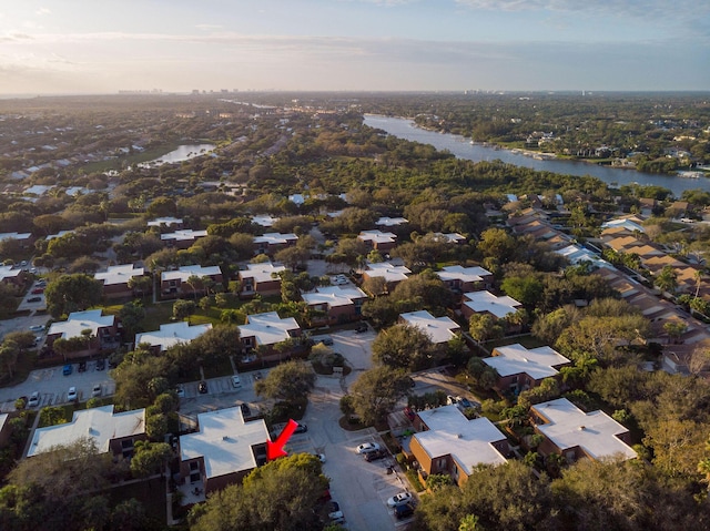 aerial view at dusk featuring a water view