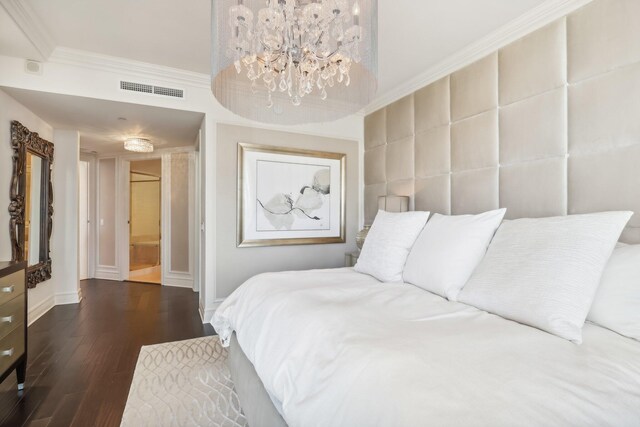 bedroom featuring dark hardwood / wood-style floors, an inviting chandelier, and ornamental molding