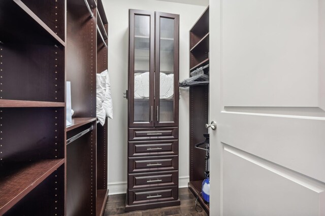 bedroom featuring a notable chandelier, ensuite bathroom, crown molding, and dark wood-type flooring