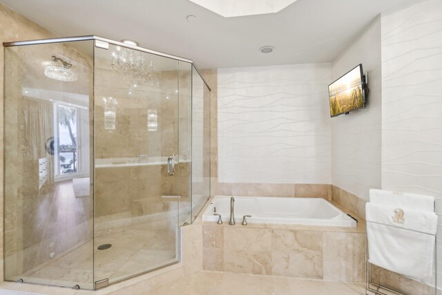 bathroom featuring vanity, tile walls, shower with separate bathtub, and an inviting chandelier