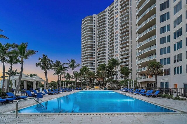 pool at dusk featuring a patio