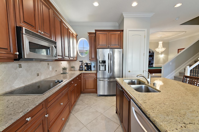 kitchen with light stone countertops, sink, hanging light fixtures, stainless steel appliances, and crown molding