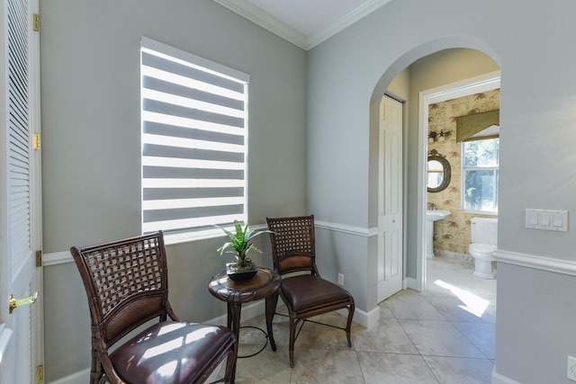 living area with light tile patterned floors and ornamental molding