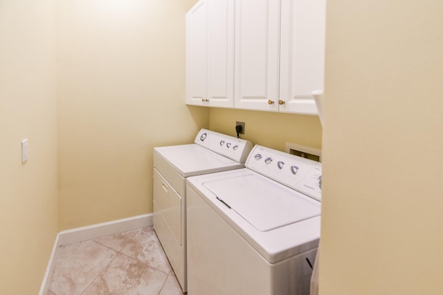 laundry room with light tile patterned flooring, cabinets, and independent washer and dryer