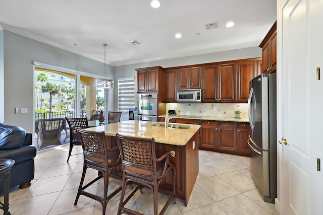 kitchen with crown molding, a center island with sink, decorative light fixtures, and appliances with stainless steel finishes