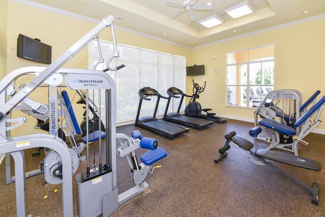 exercise room with a tray ceiling, ceiling fan, and crown molding