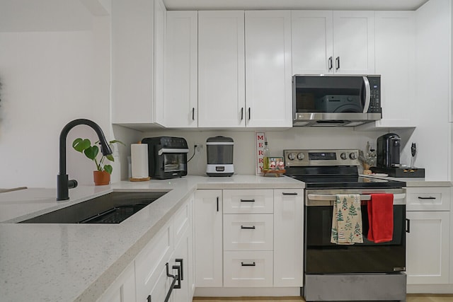 kitchen featuring white cabinetry, sink, and appliances with stainless steel finishes