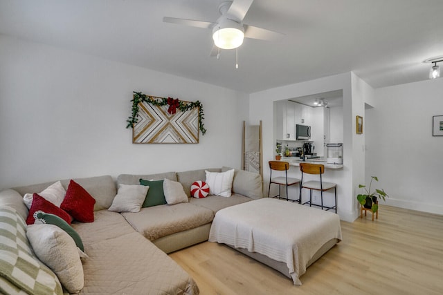 living room with light hardwood / wood-style flooring and ceiling fan