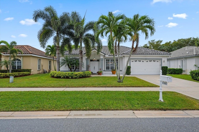 mediterranean / spanish-style home with a garage and a front lawn