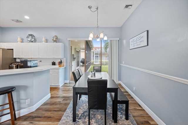 dining space featuring a notable chandelier and dark hardwood / wood-style flooring