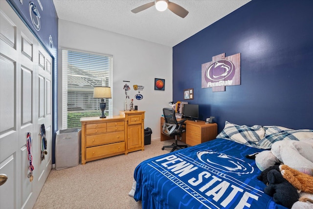 bedroom with carpet, ceiling fan, and a textured ceiling