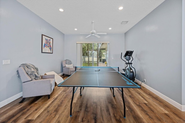 playroom with ceiling fan, hardwood / wood-style floors, and a textured ceiling