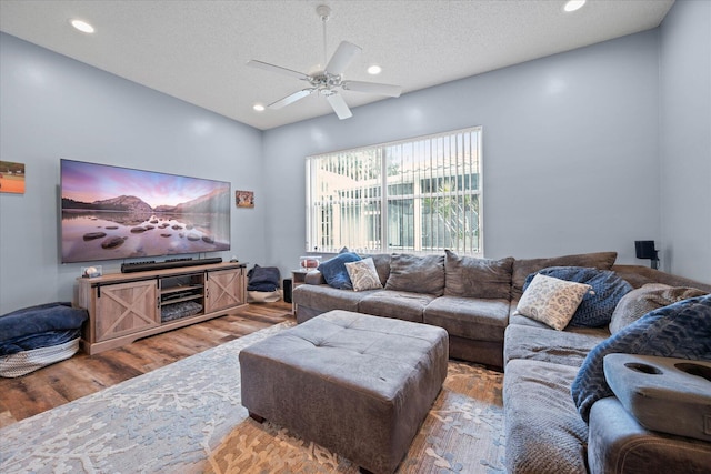 living room with wood-type flooring, a textured ceiling, and ceiling fan