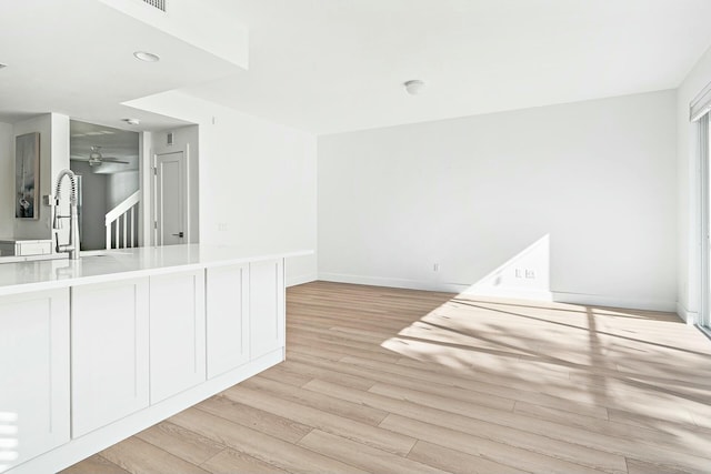 empty room featuring ceiling fan, light hardwood / wood-style floors, and sink