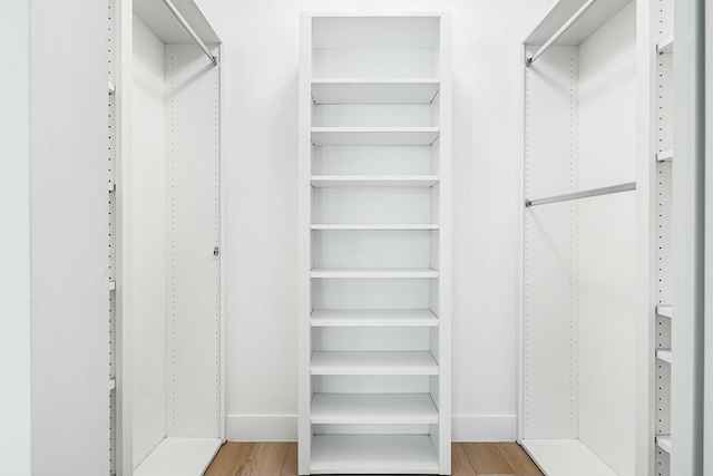 walk in closet with light hardwood / wood-style flooring