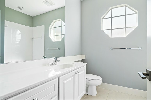 bathroom featuring toilet, vanity, tile patterned floors, and a wealth of natural light