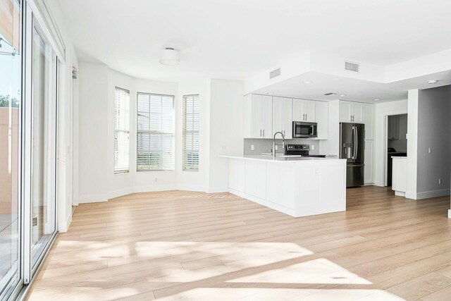 kitchen with backsplash, sink, white cabinetry, and stainless steel appliances