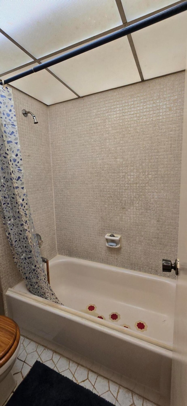 bathroom with toilet, tile patterned floors, and shower / tub combo with curtain