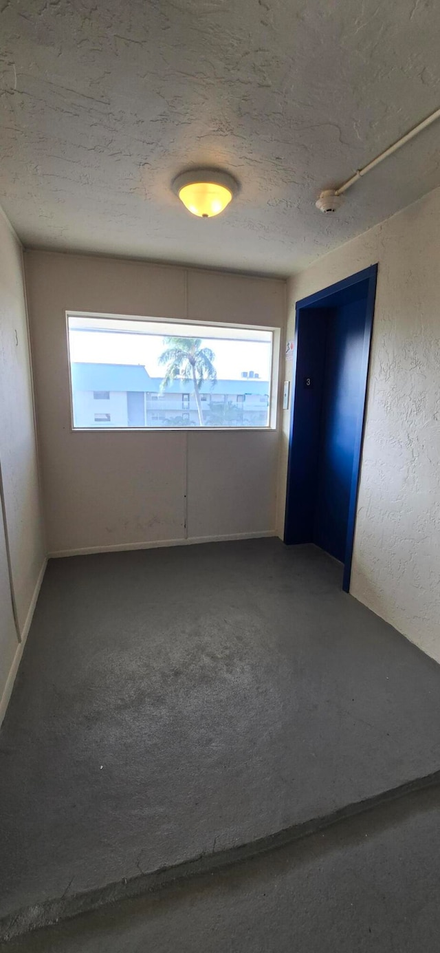 unfurnished room featuring a textured ceiling