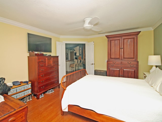 bedroom featuring ceiling fan, crown molding, and hardwood / wood-style flooring