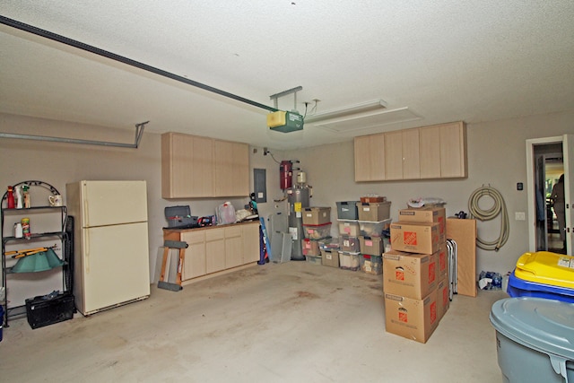 garage featuring water heater, a garage door opener, and white refrigerator