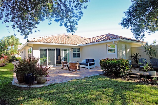 back of house with an outdoor living space, a yard, and a patio