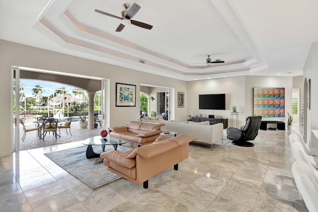 living room featuring ceiling fan and a raised ceiling