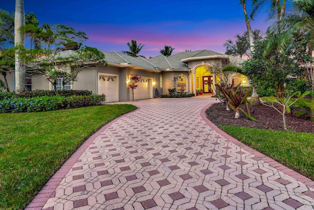 view of front facade featuring a lawn and a garage