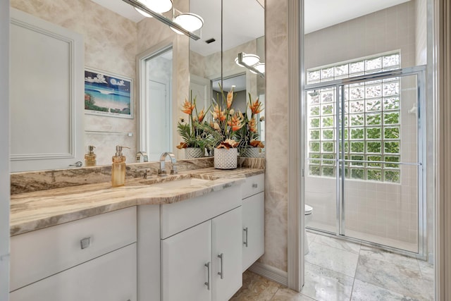 bathroom with vanity, a healthy amount of sunlight, and toilet