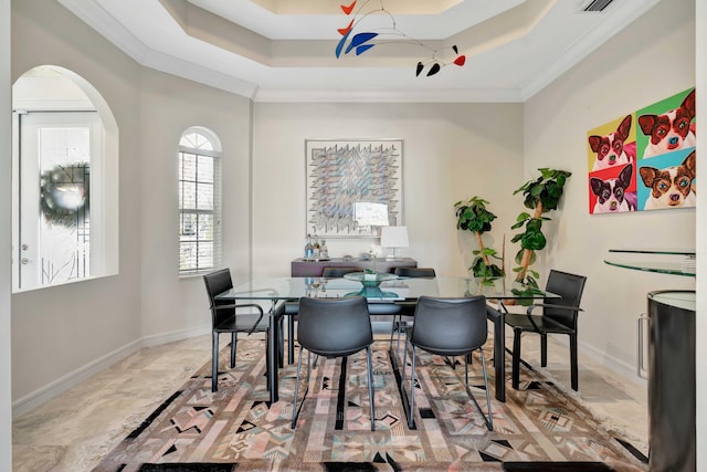 dining space with a raised ceiling and crown molding