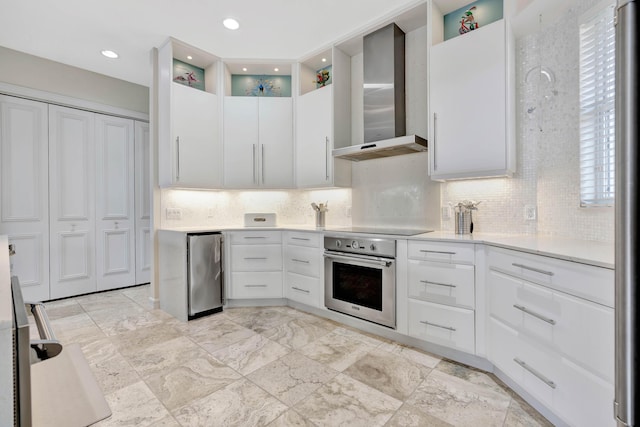 kitchen featuring white cabinetry, wall chimney range hood, and appliances with stainless steel finishes