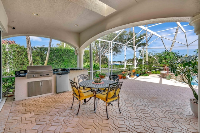 view of patio featuring a grill, a lanai, and exterior kitchen