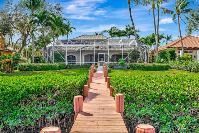 back of property featuring a lanai and a yard