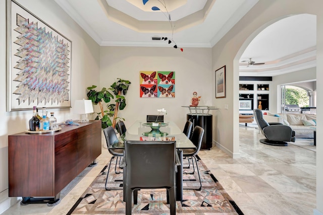 dining space featuring a raised ceiling, ceiling fan, and crown molding