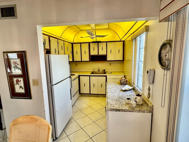 kitchen with ceiling fan, sink, backsplash, white appliances, and light tile patterned floors