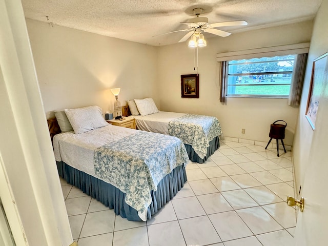 tiled bedroom with a textured ceiling and ceiling fan