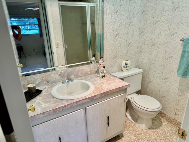 bathroom featuring vanity, toilet, and walk in shower