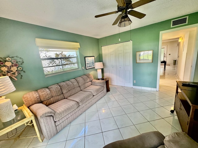 tiled living room with ceiling fan and a textured ceiling