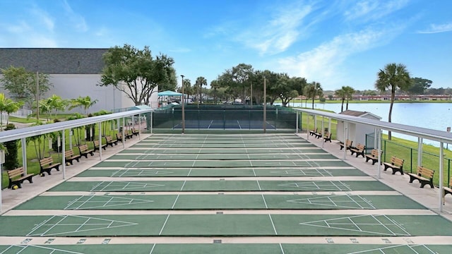 view of community with tennis court and a water view