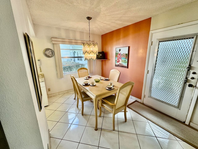 tiled dining area featuring a textured ceiling and a chandelier