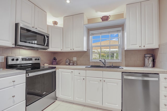 kitchen featuring backsplash, sink, white cabinetry, and stainless steel appliances