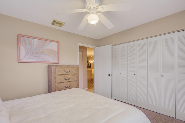 carpeted bedroom featuring ceiling fan and a closet