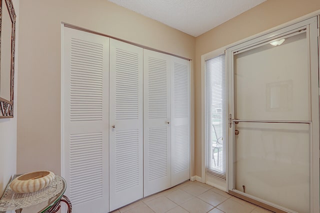 tiled foyer entrance with a textured ceiling and a wealth of natural light