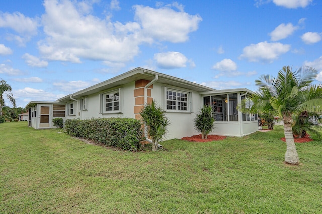 view of side of property featuring a sunroom and a yard