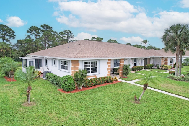 ranch-style house featuring a front yard and cooling unit